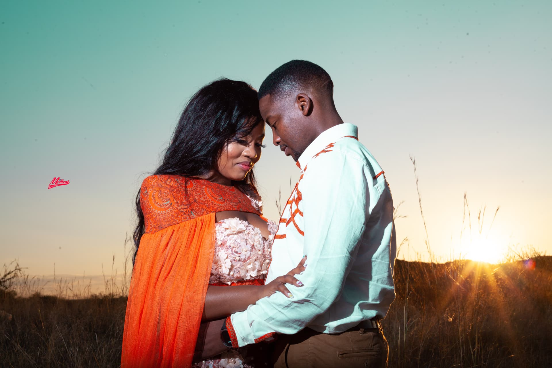 Couple embracing at sunset in an open field — emotional storytelling portrait