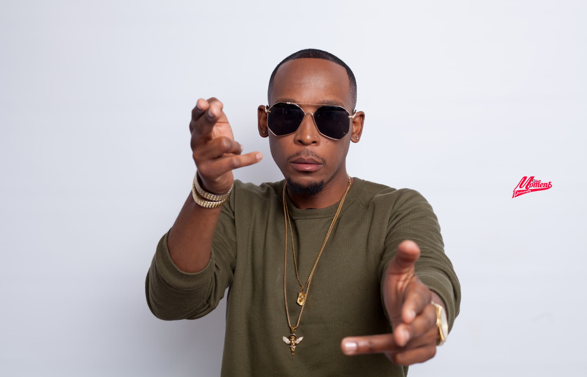 High-key studio portrait of a man in sunglasses reaching toward the camera